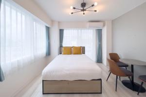 una camera da letto con un letto, un tavolo e delle sedie di Sakuramichi Terrace a Tokyo Altre 51 foto