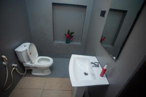 a bathroom with a white toilet and a sink at Villa Beach Zone in Talpe