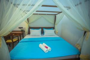 a bedroom with a blue bed with two towels on it at Villa Beach Zone in Talpe