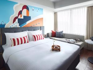 a hotel room with a large bed and a couch at Citadines Harbour Front Yokohama in Yokohama