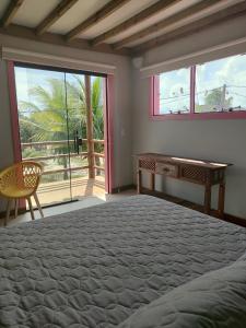 1 dormitorio con cama, escritorio y ventana en EcoFlats Caraiva en Caraíva