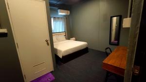 Dormitorio pequeño con cama y espejo en Jurockotel en Pattaya Central
