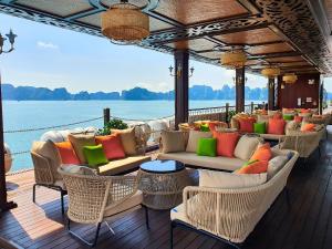 Indochine Premium Halong Bay Powered by Aston في ها لونغ: سطح السفينة به أرائك وكراسي على قارب