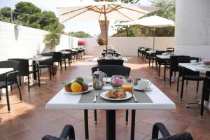 a table with a plate of food on a patio at Hotel Baia Del Capitano in Cefalù