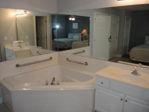 a bathroom with a tub and a large mirror at Studio Home 1203L at Brunswick Plantation Resort and Golf Villas in the Heart of NC Seafood Country studio in Calabash