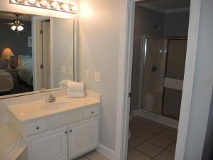 a bathroom with a sink and a shower and a mirror at Studio Home 1203L at Brunswick Plantation Resort and Golf Villas in the Heart of NC Seafood Country studio in Calabash