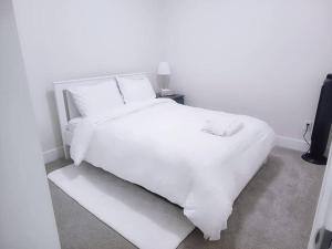 białe łóżko z białą pościelą i poduszkami w obiekcie Modern 3Bed-2.5Bath - Delta, BC w mieście Delta
