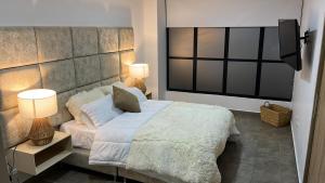 a bedroom with a large bed with two lamps at Levits in Medellín