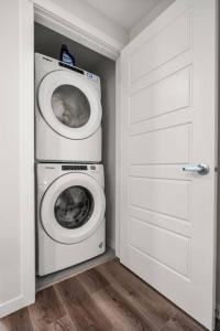 a laundry room with a washing machine and a washer at Rockland Oasis: 1BR + Parking in Calgary