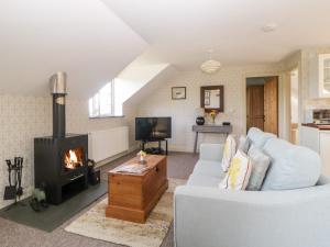a living room with a couch and a fireplace at The Hayloft in Lostwithiel