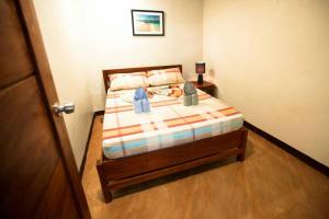 a bedroom with a bed with a striped bedspread at Apartment Ground floor in El Nido