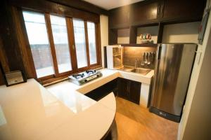 a kitchen with a stainless steel refrigerator and a sink at Apartment Ground floor in El Nido