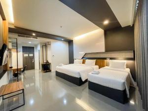 a hotel room with two beds and a television at 9D Sport Hotel in Udon Thani