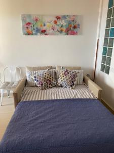 a bed with purple sheets and pillows in a room at Hibiscus Apartment-casa per le vacanze vicino tropea in Briatico