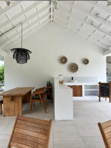 a living room with white walls and wooden furniture at Coco Villa in Thoddoo