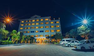 a large building with cars parked in a parking lot at Sisombat Plaza Hotel in Vang Vieng