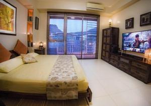 a bedroom with a large bed and a large window at Family beach apartment with lagoon view at Pico de Loro in Nasugbu