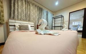 a bedroom with two beds with swans on them at The Sun House in Hua Hin