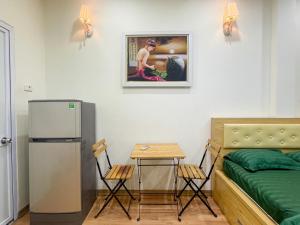 een kamer met een bed, een tafel en een koelkast bij Joy Homestay in Hanoi