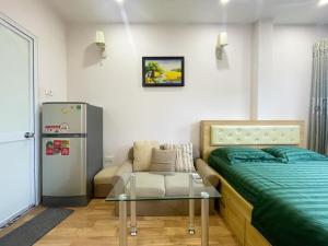a bedroom with a bed and a couch and a table at Joy Homestay in Hanoi