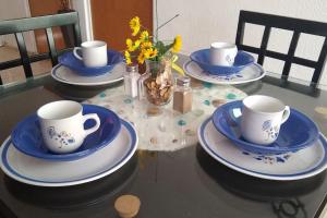 una mesa con tazas y platos azules y blancos. en Casita práctica, sencilla y lista para recibirte., en Silao