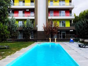 a swimming pool in front of a building at The Airport Loft in Otopeni