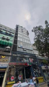 a tall building with a store in front of it at Hotel Prime Inn Mirpur 10 in Dhaka