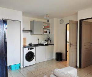a kitchen with a washing machine in a room at Résidence Muscade Saint Denis in Saint-Denis