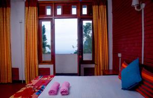- une chambre avec un lit et des chaussons roses dans l'établissement Eco Salient View, à Ella
