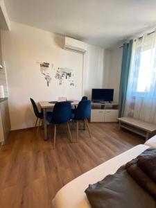 a room with a table and chairs and a tv at Studio apartman Mia in Tar