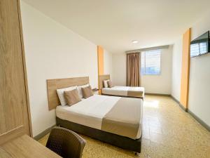 Cette chambre comprend 2 lits et une fenêtre. dans l'établissement Hotel Zamay Centro Historico, à Santa Marta
