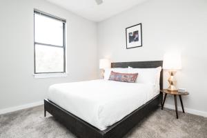 a white bedroom with a large bed and a window at CozySuites Music Row Elegant 1BR w free parking 51 in Nashville