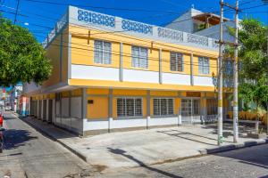 un bâtiment jaune et blanc au coin d'une rue dans l'établissement Hotel Zamay Centro Historico, à Santa Marta