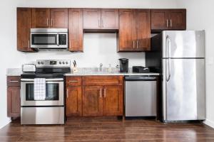 a kitchen with wooden cabinets and stainless steel appliances at CozySuites Music Row Elegant 1BR w free parking 51 in Nashville
