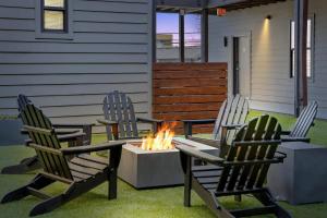 three chairs and a fire pit on a patio at CozySuites Music Row Elegant 1BR w free parking 51 in Nashville