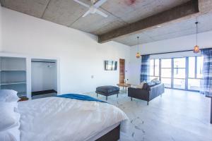 1 dormitorio con 1 cama, 1 silla y 1 sofá en Yzerfontein Villa Fantastica - No Loadshedding, en Yzerfontein