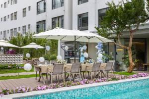 a table with chairs and an umbrella next to a pool at kasion purey Designer Hotel - Lijiang Ancient City Sifang Street in Lijiang