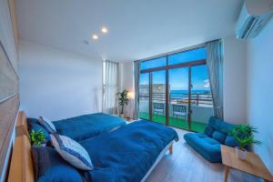 uma grande cama azul num quarto com uma grande janela em Kunigami-gun - House / Vacation STAY 47662 em Onna