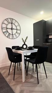 a dining room with a table and a clock on the wall at Richmond Village Apartments in Cardiff