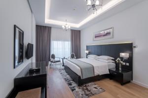 Rose Garden Hotel Apartments - Al Barsha, Near Metro Station في دبي: غرفة نوم مع سرير مزدوج كبير ومكتب