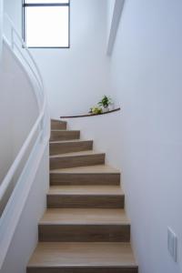 uma escadaria numa casa com paredes brancas e pisos de madeira em Kunigami-gun - House / Vacation STAY 47662 em Onna
