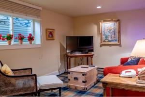 ein Wohnzimmer mit einem roten Sofa und einem TV in der Unterkunft Weyyakin Home - New Listing! Large Home for 13 Guests Just Minutes From Skiing in Ketchum