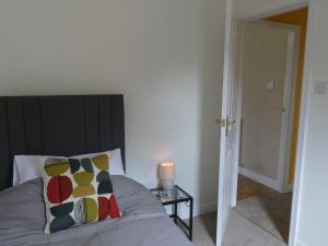 een slaapkamer met een bed met kussens en een tafel bij Red Tree Cottage in York
