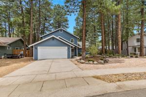 a blue house with a garage in front of trees at Family Friendly Escape~ Close to Downtown ~Airport ~Sedona & Grand Canyon in Flagstaff