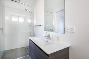 a white bathroom with a sink and a shower at Pipers Spot - Pet Friendly - Fireplace with Swimming Pool in Culburra Beach +23 photos