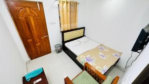 a small bedroom with a small bed and chairs at Hotel Prime Inn Mirpur 10 in Dhaka