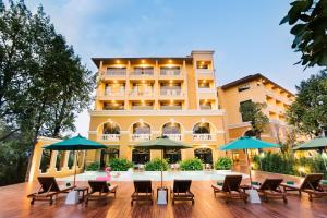 クラビタウンにあるThe Pineapple Hotelの椅子とテーブル、パラソル付きのホテル