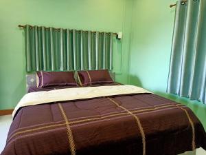 1 dormitorio con 1 cama grande y paredes verdes en วรรณรีสอร์ทwanresort, en Seka
