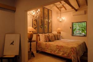 a bedroom with a bed and a chandelier at Casa Heliconia in Gampaha