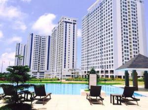 un grupo de sillas y una piscina con edificios altos en Wind Residence T4-R Near Tourist Spots/ Sky Lounge, en Tagaytay